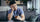 Asian man holding a drink and experiencing a headache while dealing with hangover symptoms